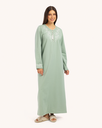 Un long harm galabiya avec un cou Rond et une brooderie chuchotée sur la poitrine et un pendentif